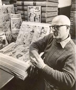 Blackbeard seated at a table covered in comics