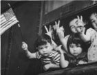 Bainbridge Island (Wash.) evacuation -- Group of young evacuees wave from special train as it leaves Seattle with Island evacuees, March 30, 1942