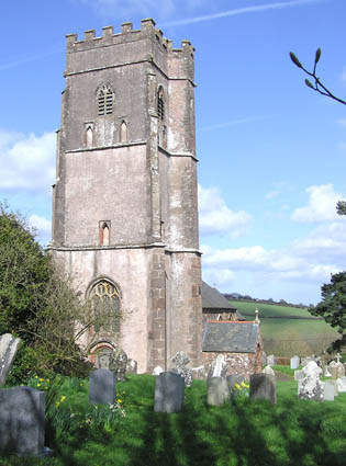 Square stone tower with gravestones in the foreground.