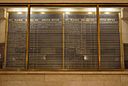 A large blackboard for train schedules, hanging behind glass