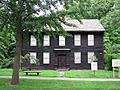 A brown colonial frame house.