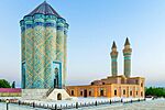 Garabaghlar Mausoleum with intricate decoration and two minarets in the background