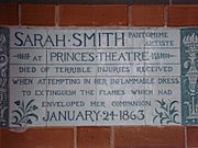 A tablet formed of six standard sized tiles, bordered by green flowers in the style of the Arts and Crafts movement