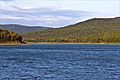 Shining blue water with the Ozark Mountains rising in the background