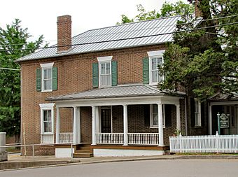 Two-story brick building fronted with wooden porch