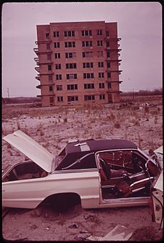 ABANDONED CAR AND UNFINISHED APARTMENT HOUSE CONSTRUCTION OF HIGHRISES ON BREEZY POINT PENINSULA WAS STOPPED BY CITY... - NARA - 547917