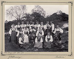 Gruppbild av personalen på Skansen, kullor och en man i mitten. Gåva till Arthur Hazelius - Nordiska Museet - NMA.0044869