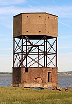 View of a tall hexagonal building comprising a brick structure standing on an open framework above another brick structure