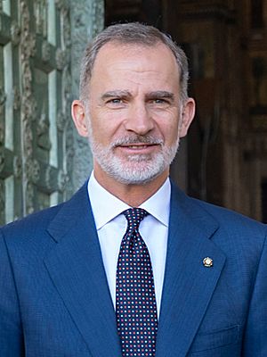 Felipe is pale-eyed, with a white beard, and wears a suit and teal-coloured tie.