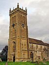 Yellow stone building with square tower.