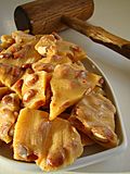 Golden peanut brittle cracked on a serving dish.jpg