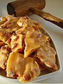 Golden peanut brittle cracked on a serving dish.jpg