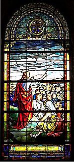 Christ standing on mountain, stretches his arm towards the people gathered to hear Him speak.