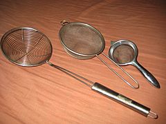 Several wire meshes shaped like bowls, with metal handles.