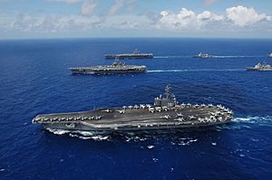 US Navy 060618-N-8492C-276 The Nimitz-class aircraft carrier USS Ronald Reagan (CVN 76), foreground, USS Kitty Hawk (CV 63), center, USS Abraham Lincoln (CVN 72) and their associated carrier strike groups steam in formation