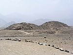 Ruins of two pyramids in a desert landscape.