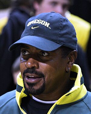 Head and shoulders photograph of Rashad wearing a blue baseball cap bearing the Oregon Ducks logo