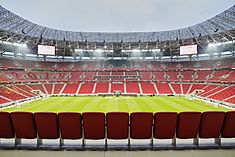 Photograph of a modern football stadium's interior; the stands are full of spectators