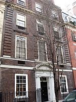  A brownish brick townhouse with stone trim