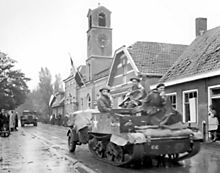 Light Infantry carriers move through Krabbendijke on the Beveland Causeway