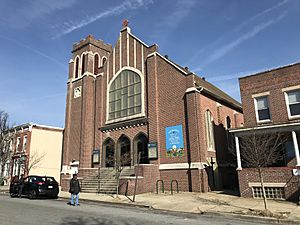 Brick church in the middle of a block of rowhouses.