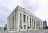 A three-quarter view of an Art Deco marble building seen from across ths street