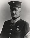 Top half of a serious man in formal 1920s U.S. military dress wearing two star-shaped medals on ribbons around his neck.