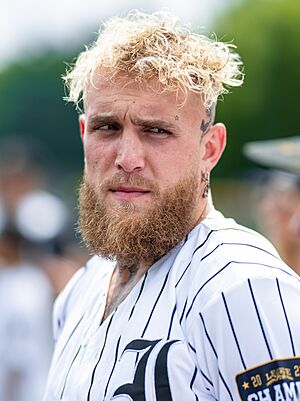 Headshot of Jake Paul, a white, young man with short, blond hair and beard, wearing a shorts jersey.