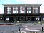 A brown-bricked building with a rectangular, black sign reading "OAKWOOD STATION" in white letters all under a light blue sky