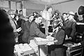 Tea and buns are supplied by local Air Raid Precautions (ARP) workers to fellow ARP workers and civilians in this basement shelter in South East London during 1940. D1623