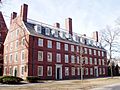 A large brick building with 6 chimneys. It is 12 windows wide and four deep; there are two doors on the front and one on the side.