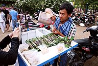 Penjual otak-otak menuang sambal kacang