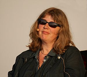 A photograph of a middle-aged woman wearing sunglasses