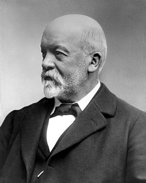 Black and white portrait of a grey haired man with a beard