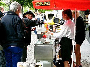 Man köper en varmkorv Almedalsveckan 2014 Visby