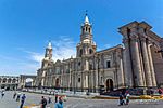 Facade of a very large white church with two tall towers.