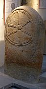 10th- or 11th-century carved stone slab, showing a cross in the style of a cart-wheel.