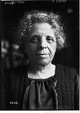 A black-and-white photograph of the head and torso of an elderly woman