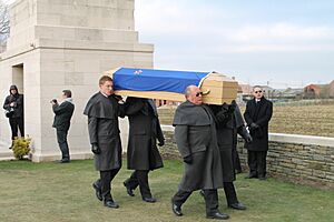 Pallbearers carry the coffin to the grave