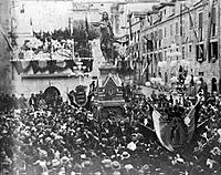 Mass of people around a statue.