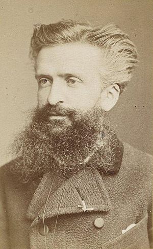 Portrait of a man in his thirties with swept back hair and a large beard