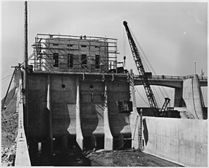 Looking upstream in the outlet channel. Form work has been stripped from the outlet control tower and service bridge... - NARA - 295321