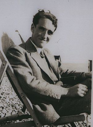 Charles Brasch, sitting on beach, date unknown (cropped)