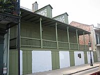 A photograph of the facade of a green house.