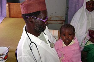 A young girl sits with a doctor receiving medical care