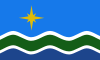 Flag comprising gold star on a light blue field with white, green, and dark blue waves below