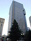 Ground-level view of a 40-story skyscraper with a tan facade; minor setbacks are visible around the tower's 30th floor