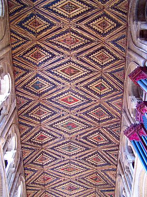 This wooden ceiling is painted in red, yellow and brown with figurative motifs framed in diamond shapes