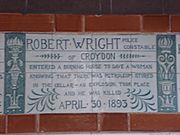 A tablet formed of six standard sized tiles, bordered by green flowers in the style of the Arts and Crafts movement