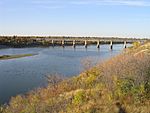 A wide river flows under a bridge.